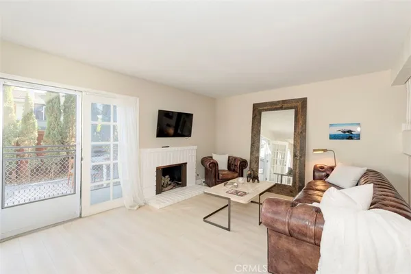 a living room with furniture a large window and a fireplace