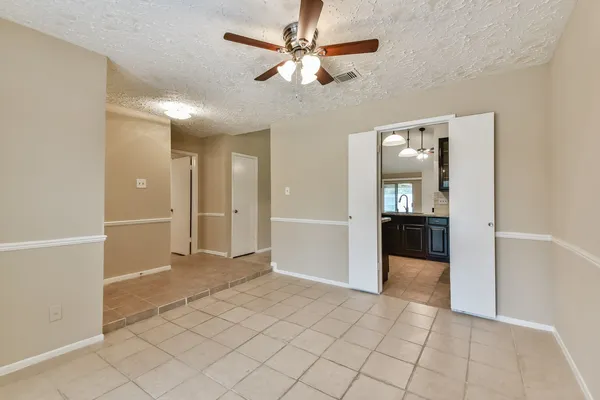wooden floor with white walls and chandelier fan in a room