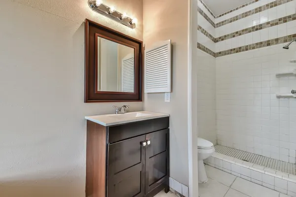 a bathroom with a sink a toilet and mirror