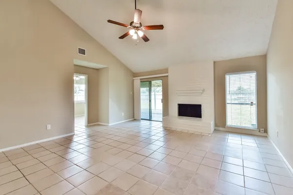 a view of an empty room with a fireplace and a window