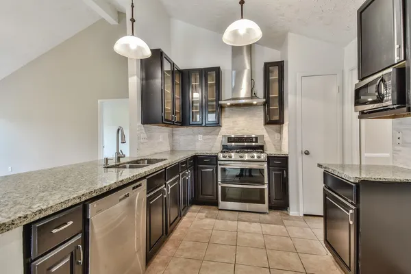 a kitchen with stainless steel appliances granite countertop a stove and a sink