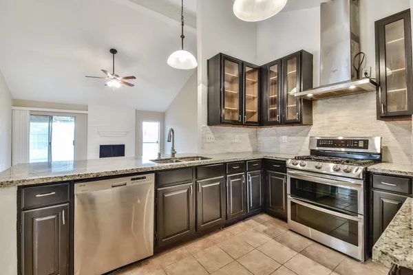 a kitchen with stainless steel appliances granite countertop a stove sink and cabinets