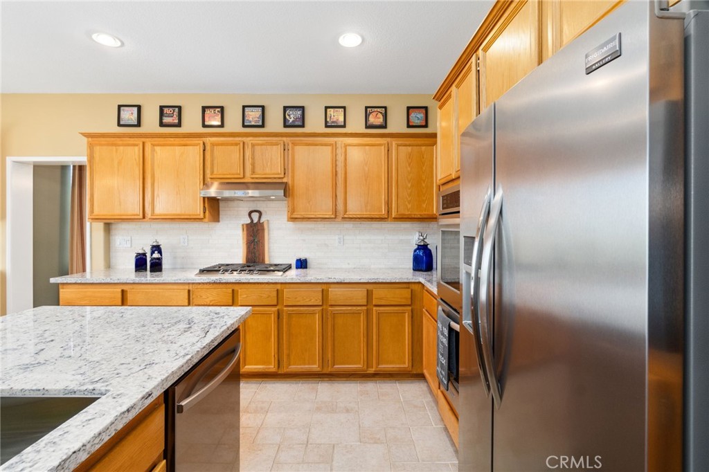 13939 Guidera Drive Rancho Cucamonga, CA 91739 - Photo 11 of 46 a kitchen with stainless steel appliances granite countertop a refrigerator and a sink