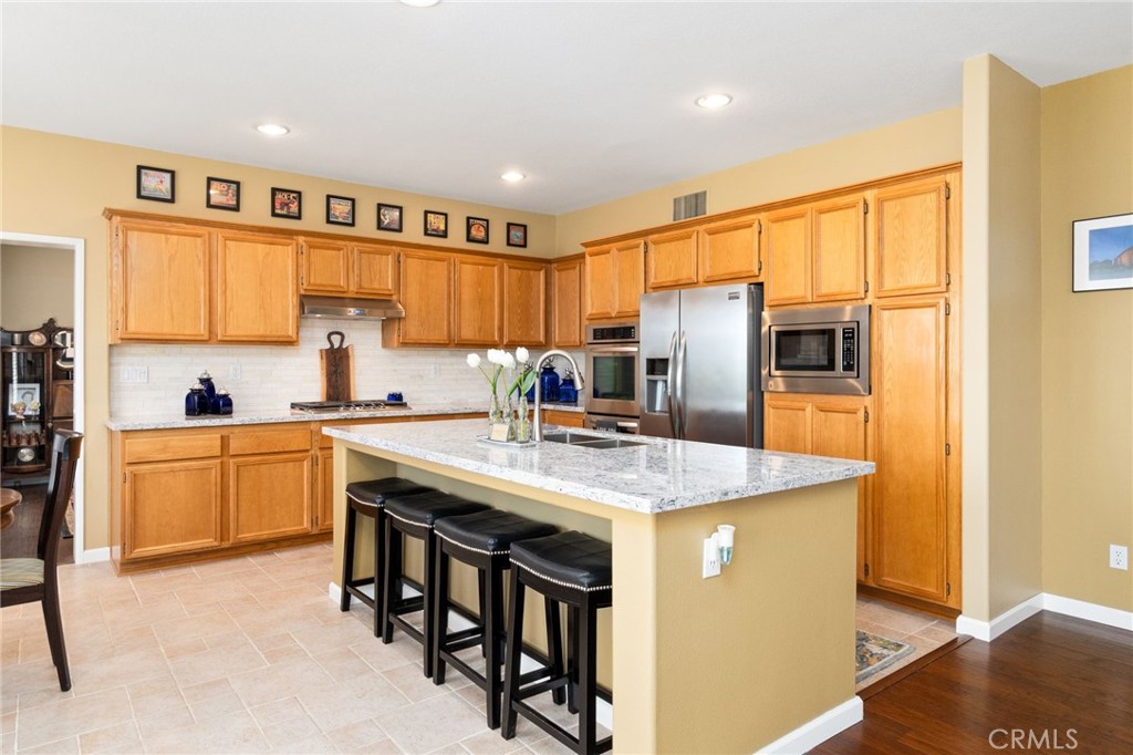 13939 Guidera Drive Rancho Cucamonga, CA 91739 - Photo 9 of 46 a kitchen with stainless steel appliances granite countertop a refrigerator a sink a stove and a refrigerator