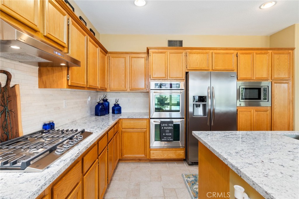 13939 Guidera Drive Rancho Cucamonga, CA 91739 - Photo 10 of 46 a kitchen with stainless steel appliances granite countertop a refrigerator a stove and a sink