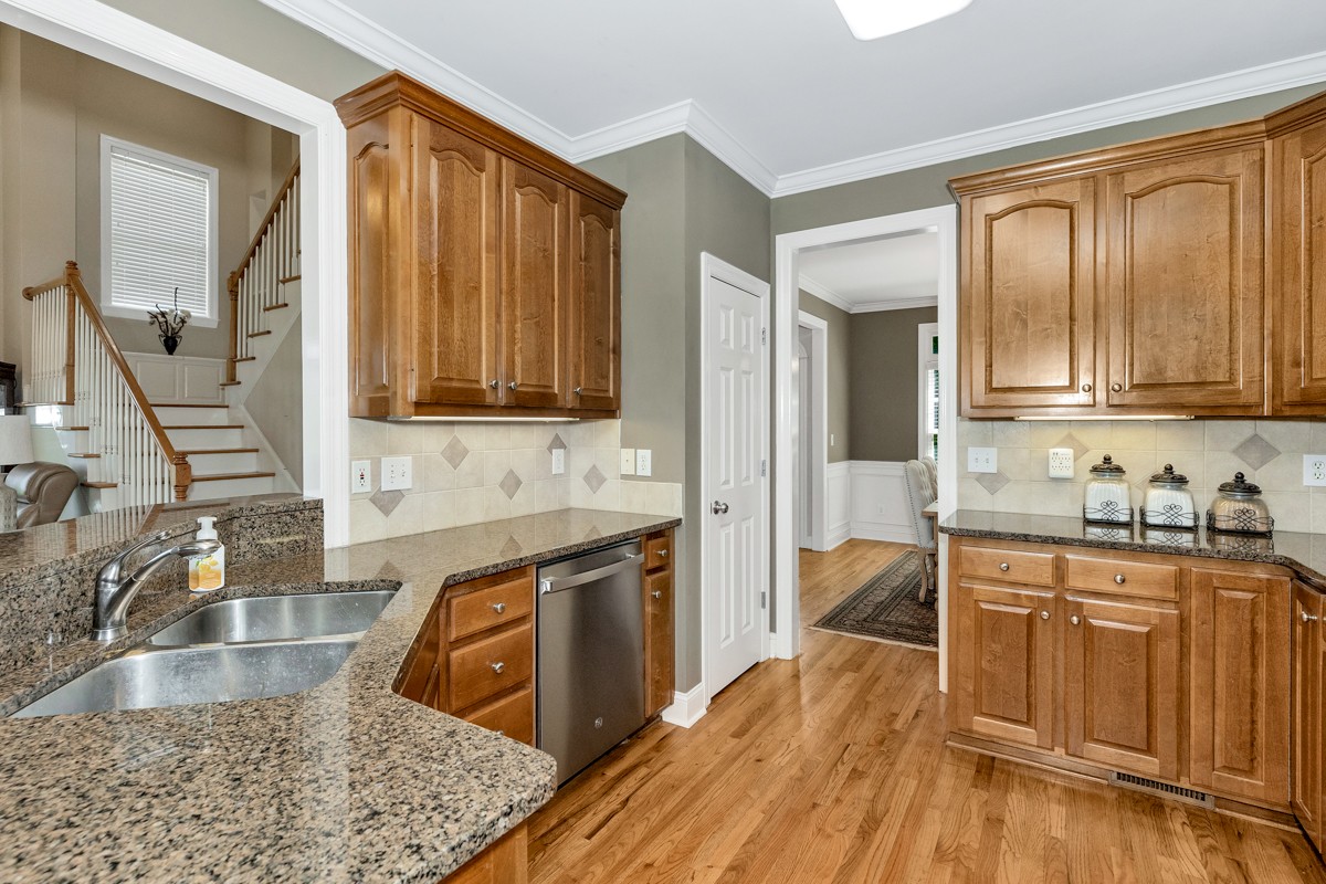 11035 Mathis Mountain Road Southeast Huntsville, AL 35803 - Photo 39 of 40 a kitchen with stainless steel appliances granite countertop wooden cabinets a sink and dishwasher a stove with wooden floor