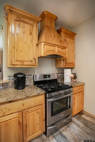 a utility room with fridge and wooden floor