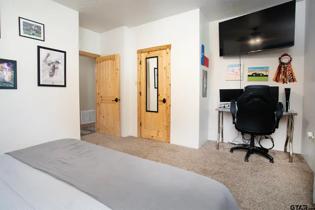 a spacious bedroom with a bed and a chandelier