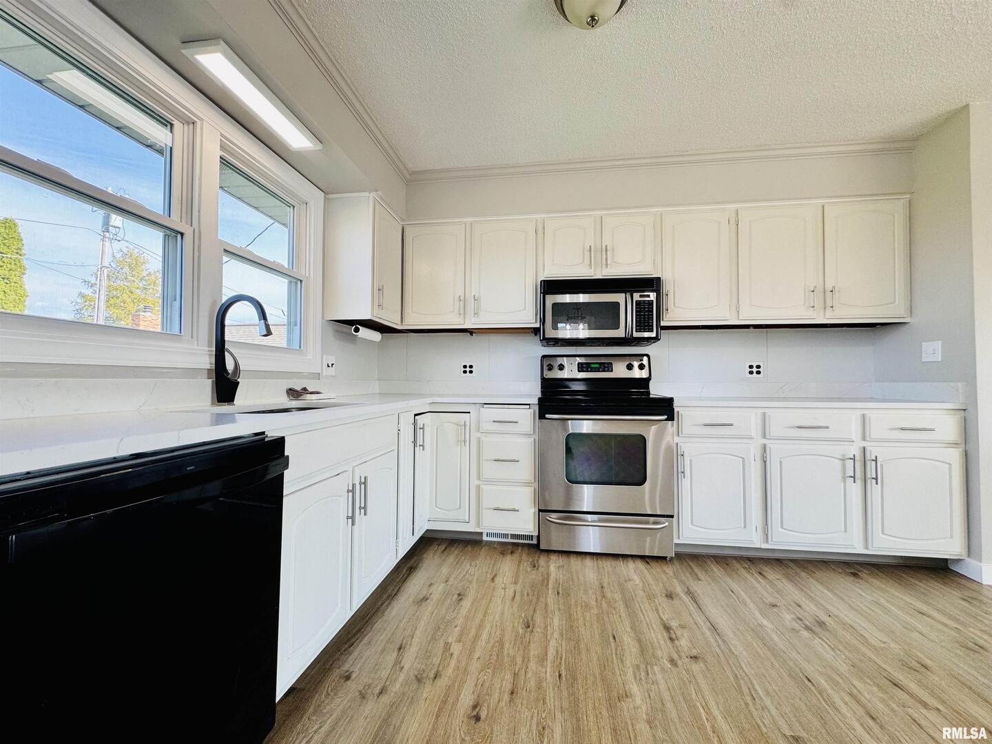 708 Tower Road Clinton, IA 52732 - Photo 13 of 34 a kitchen with granite countertop white cabinets and stainless steel appliances
