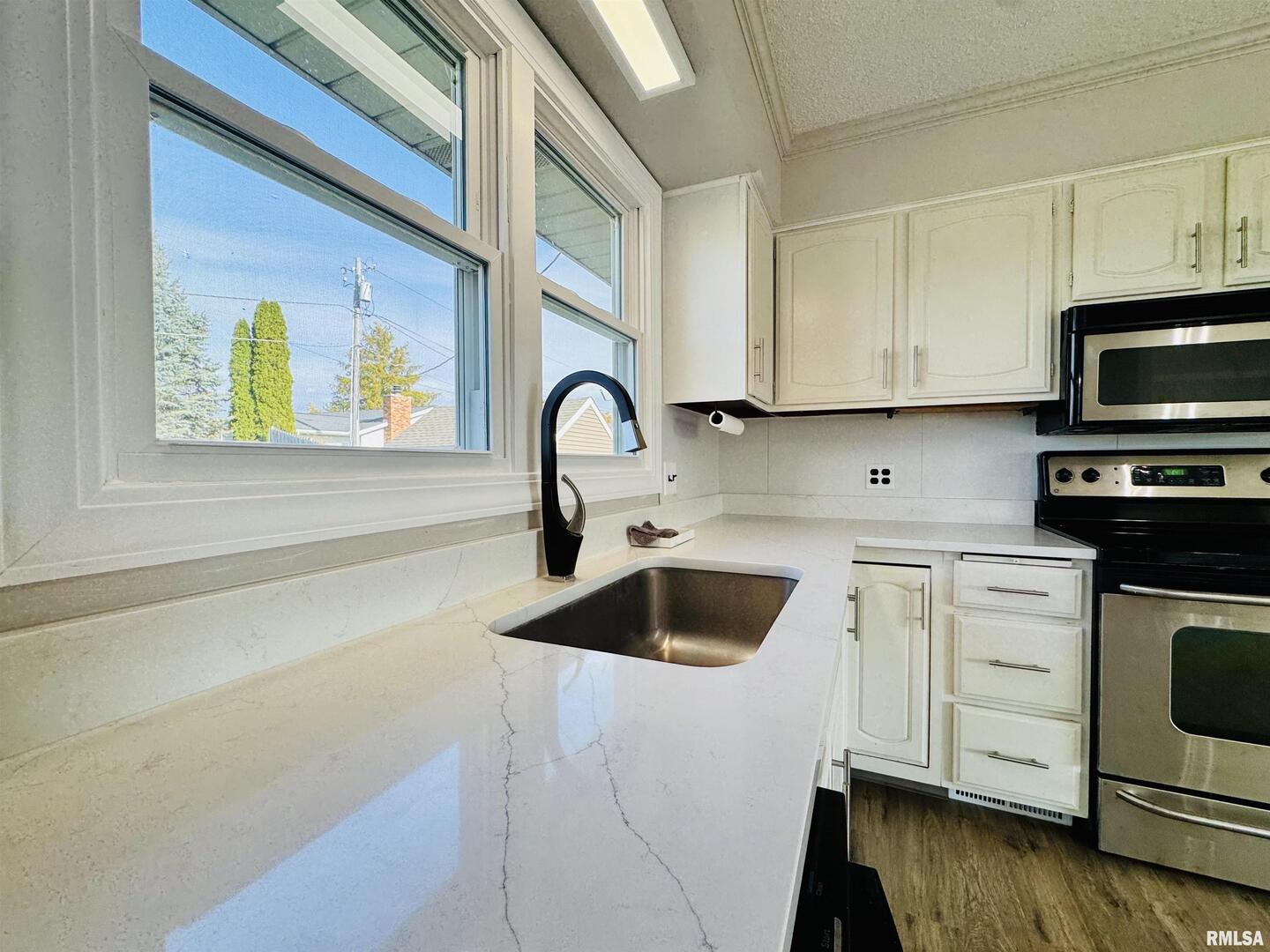 708 Tower Road Clinton, IA 52732 - Photo 14 of 34 a kitchen with stainless steel appliances granite countertop a sink and a stove top oven