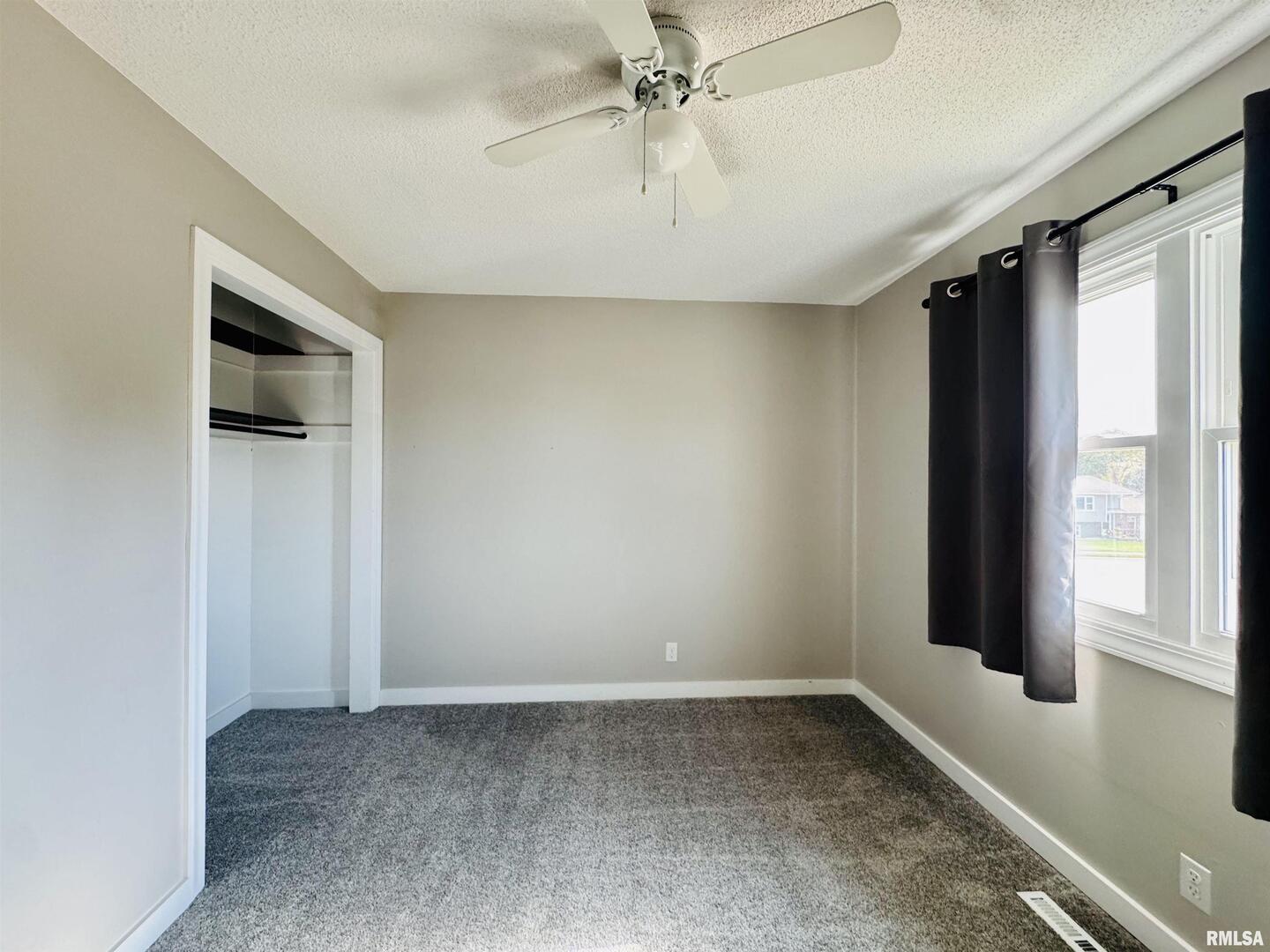 708 Tower Road Clinton, IA 52732 - Photo 20 of 34 an empty room with a window and a ceiling fan