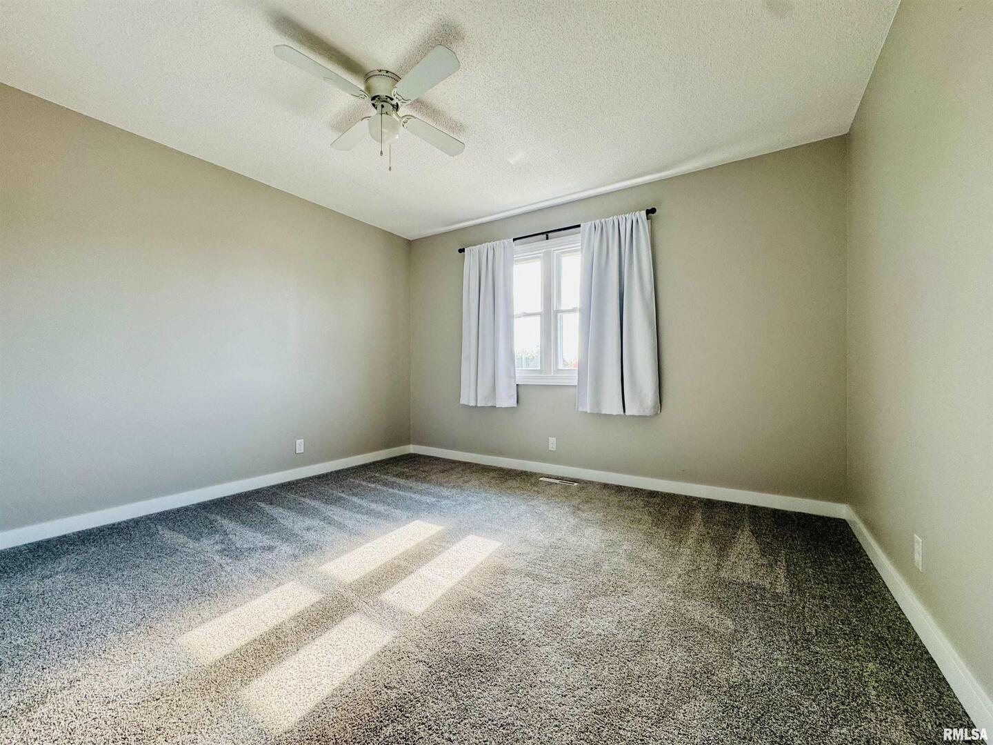 708 Tower Road Clinton, IA 52732 - Photo 21 of 34 an empty room with a window and a ceiling fan