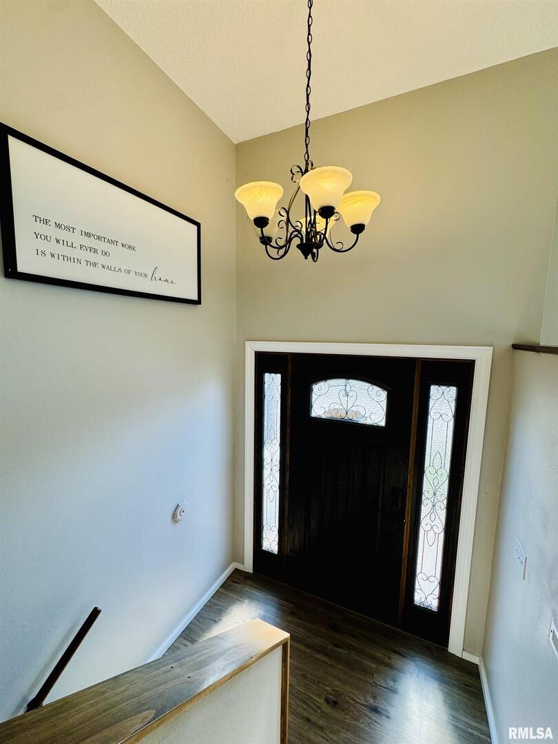 708 Tower Road Clinton, IA 52732 - Photo 6 of 34 a view of a hallway with wooden floor and chandelier
