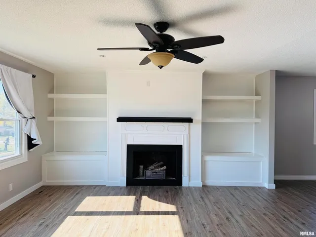 a living room with a fireplace and a ceiling fan