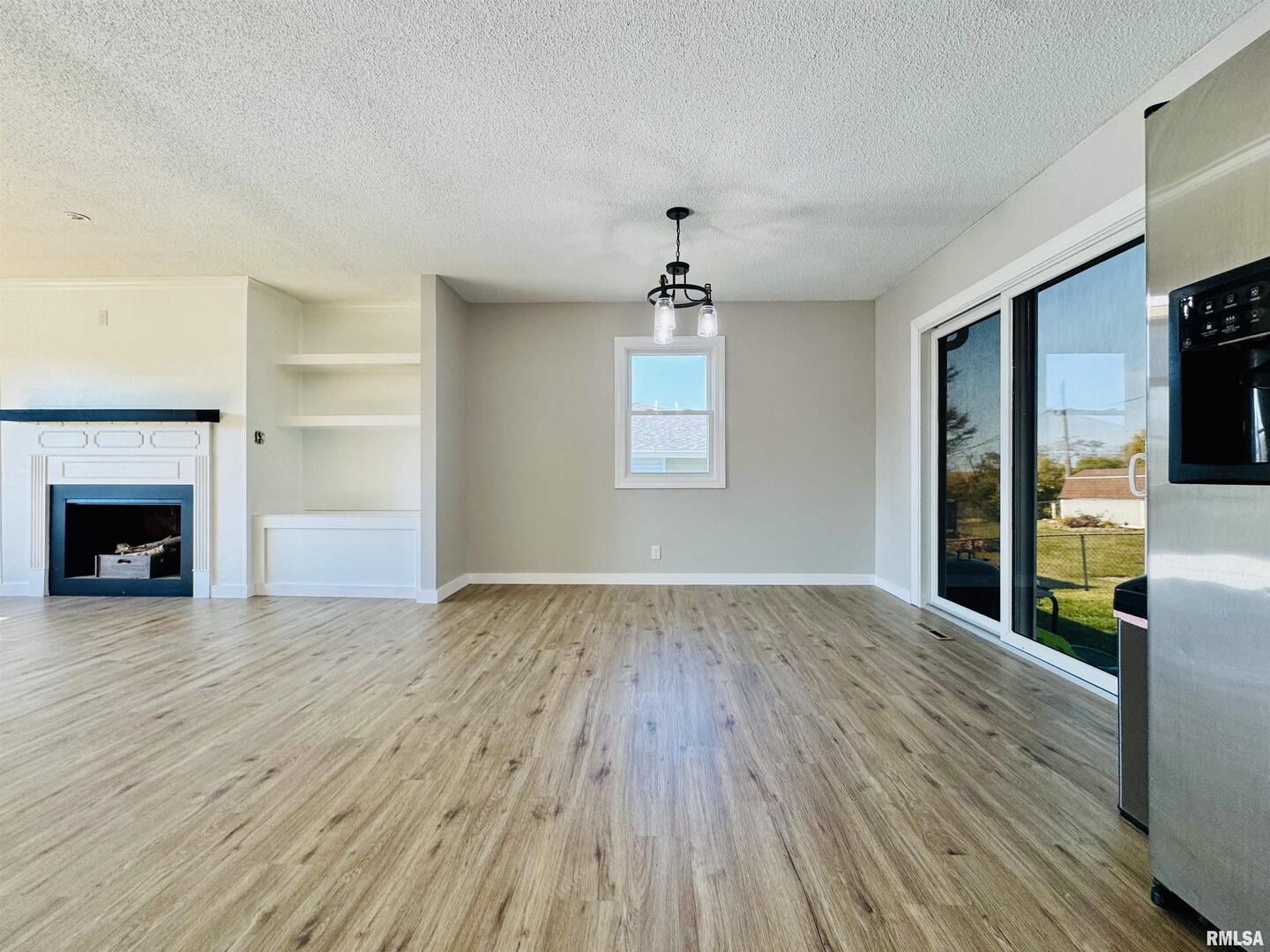 708 Tower Road Clinton, IA 52732 - Photo 10 of 34 a view of an empty room with wooden floor fireplace and a window
