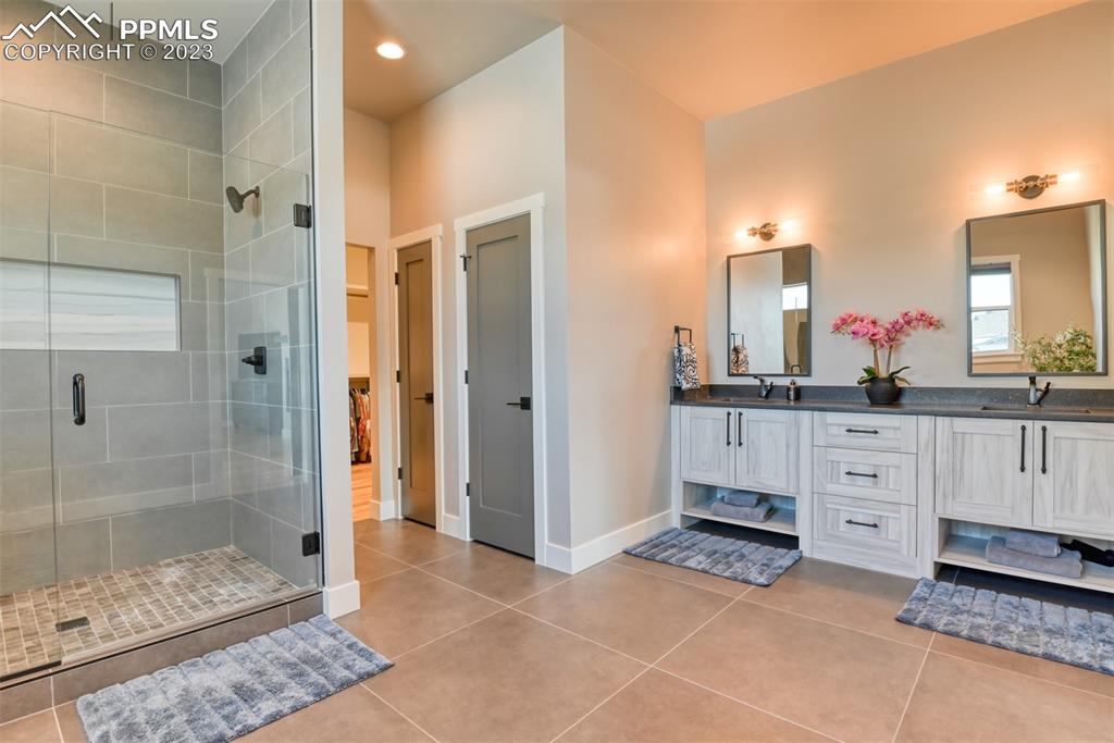 14149 Stone Eagle Place Colorado Springs, CO 80921 - Photo 39 of 47 a bathroom with a shower sink and mirror