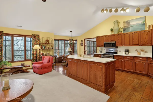 a kitchen with stainless steel appliances kitchen island granite countertop a stove a sink dishwasher and a microwave oven with cabinets