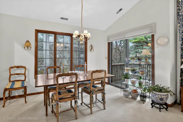 a dining room with furniture and a floor to ceiling window