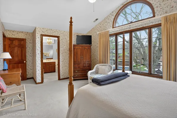 a spacious bedroom with a bed and a large window