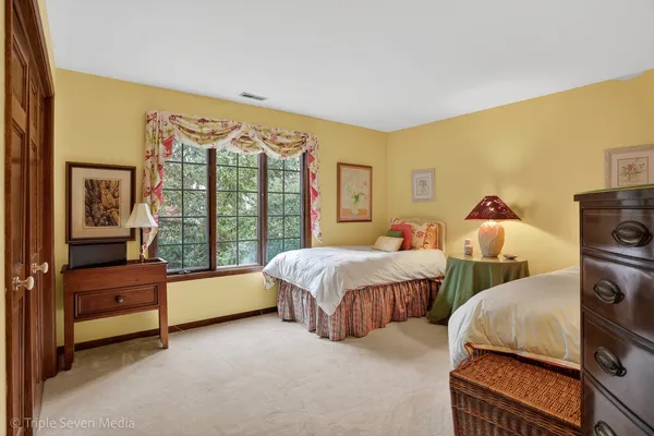 a spacious bedroom with two beds and large window