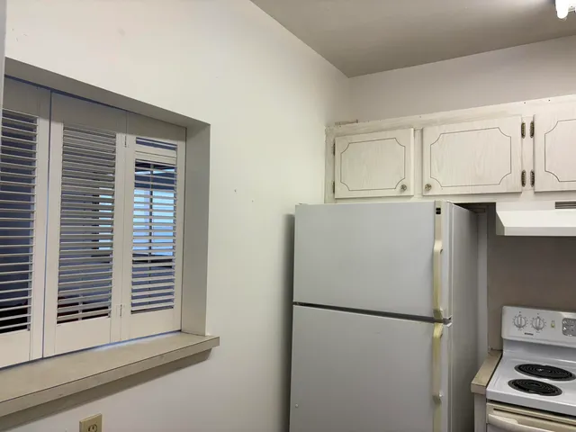 a white refrigerator freezer and a stove sitting inside of a kitchen
