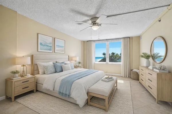 a spacious bedroom with a bed a mirror and a chandelier