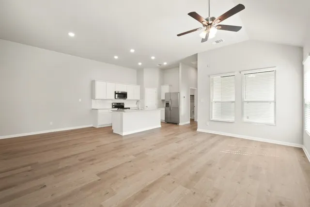 a view of a kitchen with a sink hardwood floor and a ceiling fan
