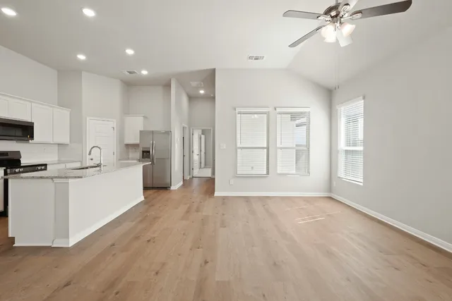 a large white kitchen with wooden floors and white walls