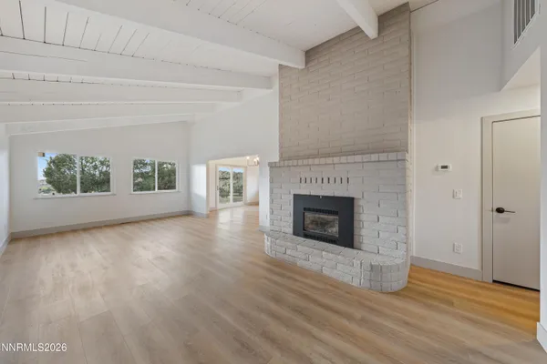a view of a livingroom with wooden floor and a fireplace