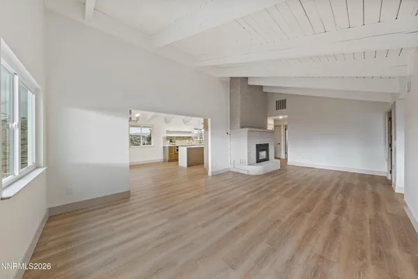 a view of empty room with wooden floor and fireplace