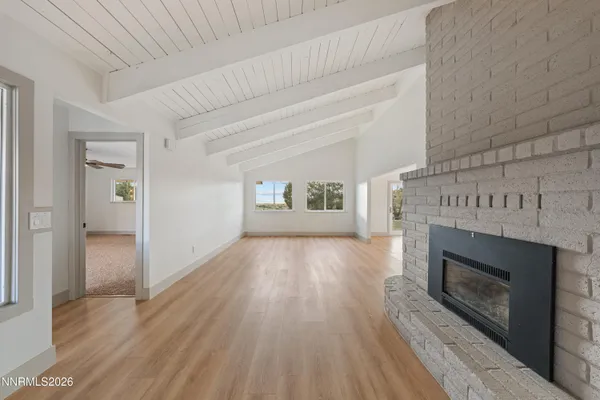 a view of an empty room with a fireplace and a window