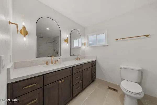 a spacious bathroom with a toilet sink and mirror