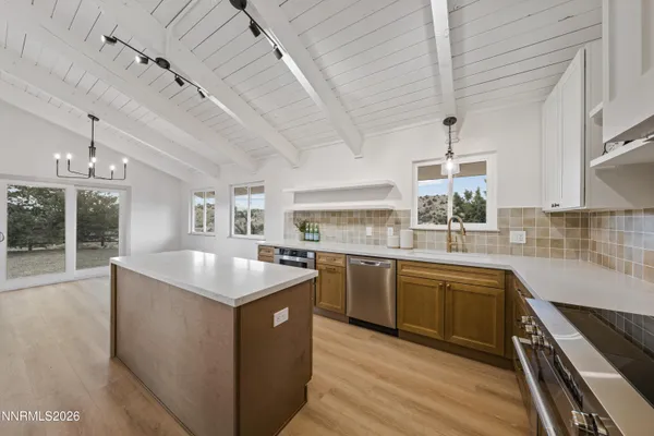 a kitchen with kitchen island granite countertop lots of counter top space and stainless steel appliances