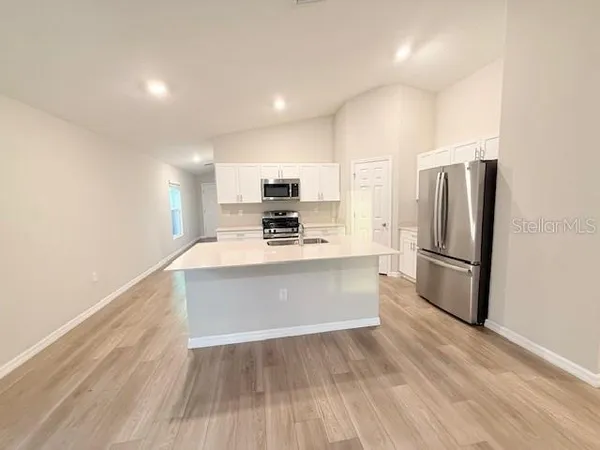 a kitchen with stainless steel appliances a refrigerator and a stove top oven