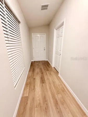 a view of a room with wooden floor and a window