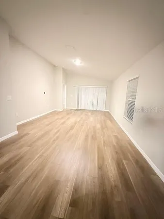 a view of an empty room and wooden floor