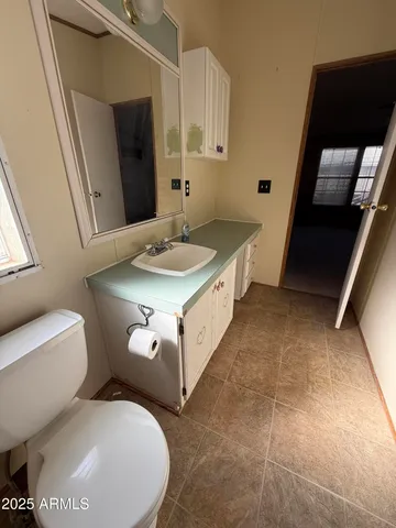 a bathroom with a toilet sink and mirror