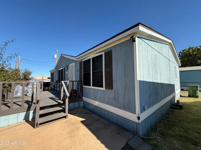 a view of wooden house with a small yard and wooden fence
