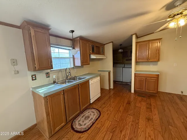 a kitchen with a sink and wooden floor