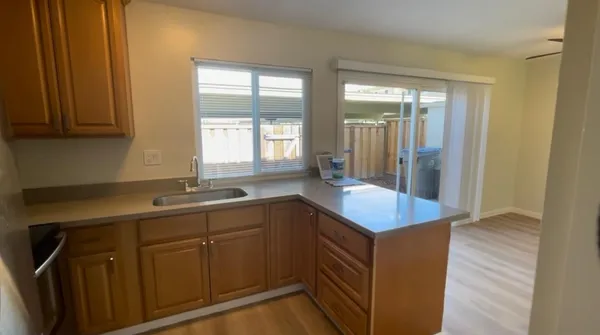 a kitchen with a refrigerator and wooden floor