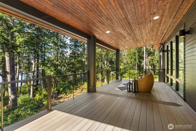 a balcony with wooden floor table and chairs