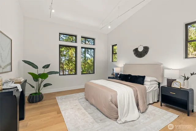a bedroom with a large bed and a potted plant