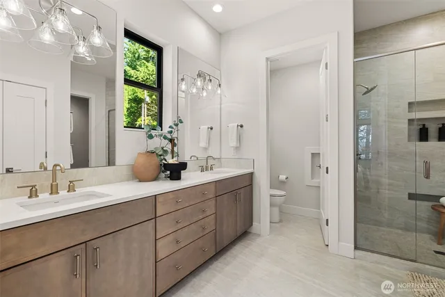a bathroom with a double vanity sink toilet and shower