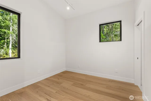 an empty room with wooden floor and window