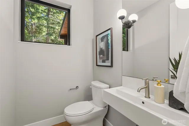 a bathroom with a toilet sink and mirror