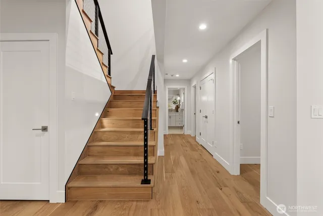 a view of a hallway with wooden floor and entryway