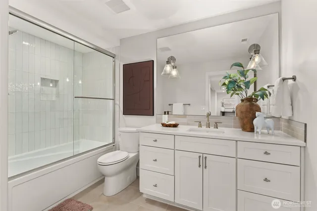 a bathroom with a granite countertop sink a toilet and shower