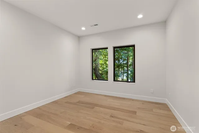 an empty room with wooden floor and window