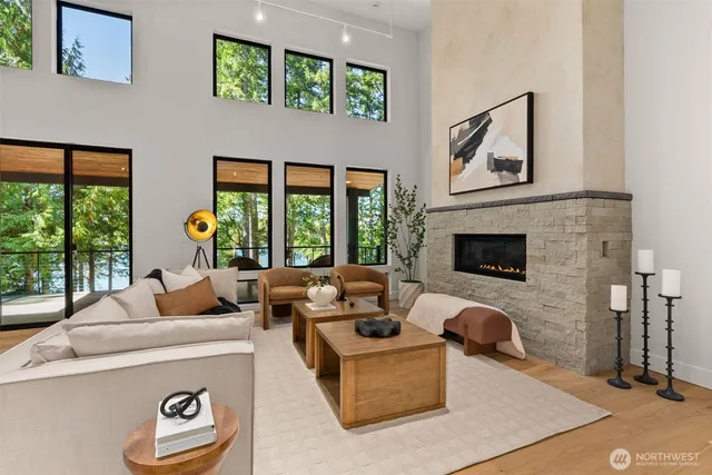 a living room with furniture a floor to ceiling window and a fireplace