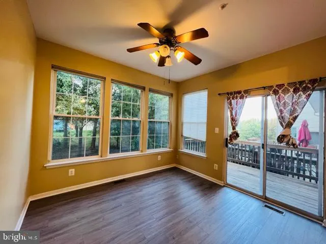 a view of an entryway with wooden floor and a ceiling fan